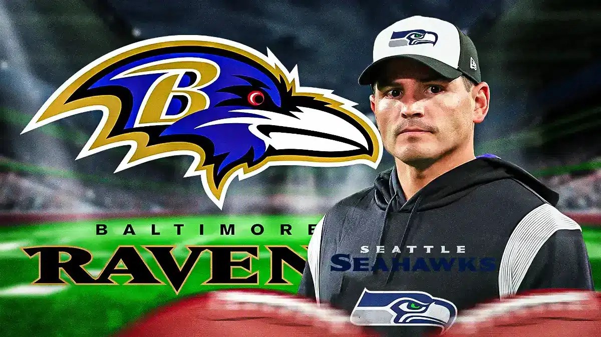 Photo: Mike Macdonald in Seahawks gear with Ravens logo behind him