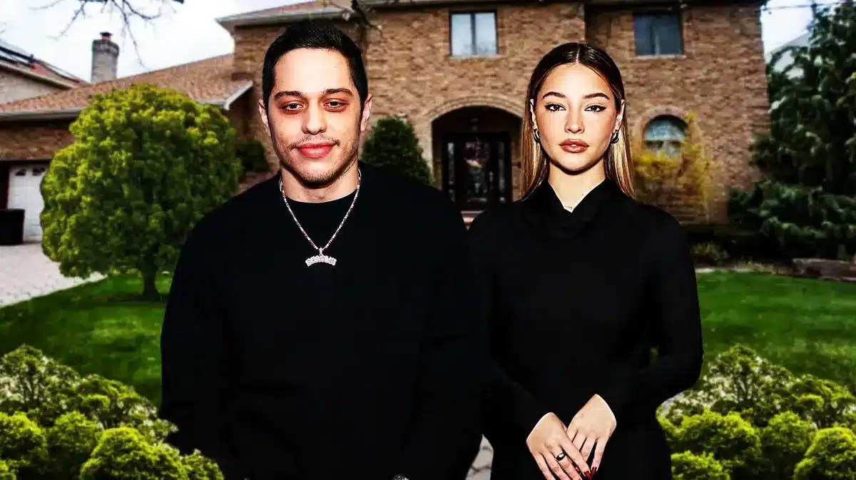 Pete Davidson and Madelyn Cline with a house behind them
