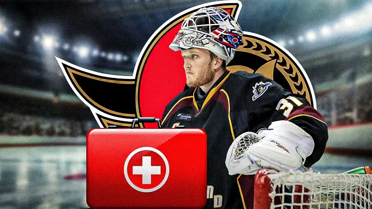 Anton Forsberg in middle of image looking stern, first aid kit, OTT Senators logo, hockey rink in background