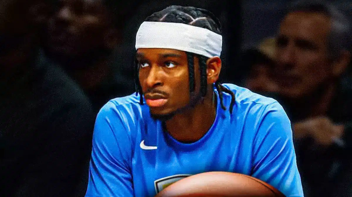 Thunder’s Shai Gilgeous-Alexander sitting down on an NBA sideline looking serious.