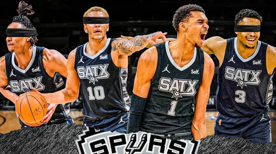 Spurs' Victor Wembanyama smiling, with Jeremy Sochan, Devin Vassell, and Keldon Johnson blindfolded