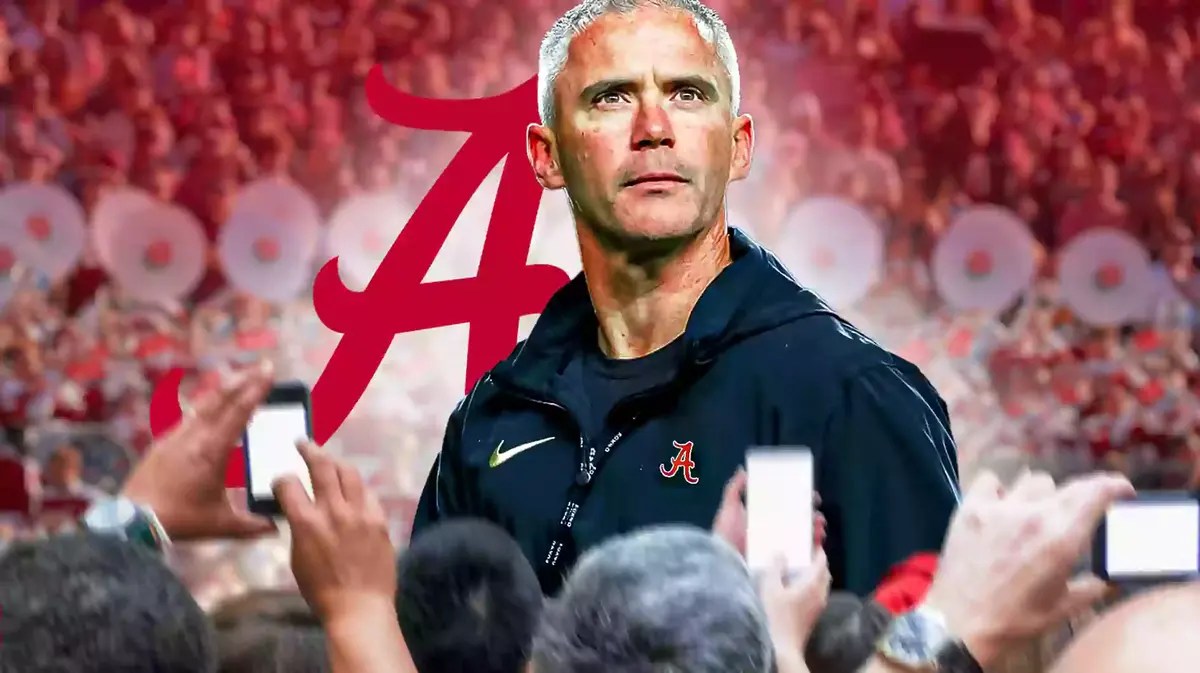 Photo: Mike Norvell in Alabama gear with Alabama logo behind him