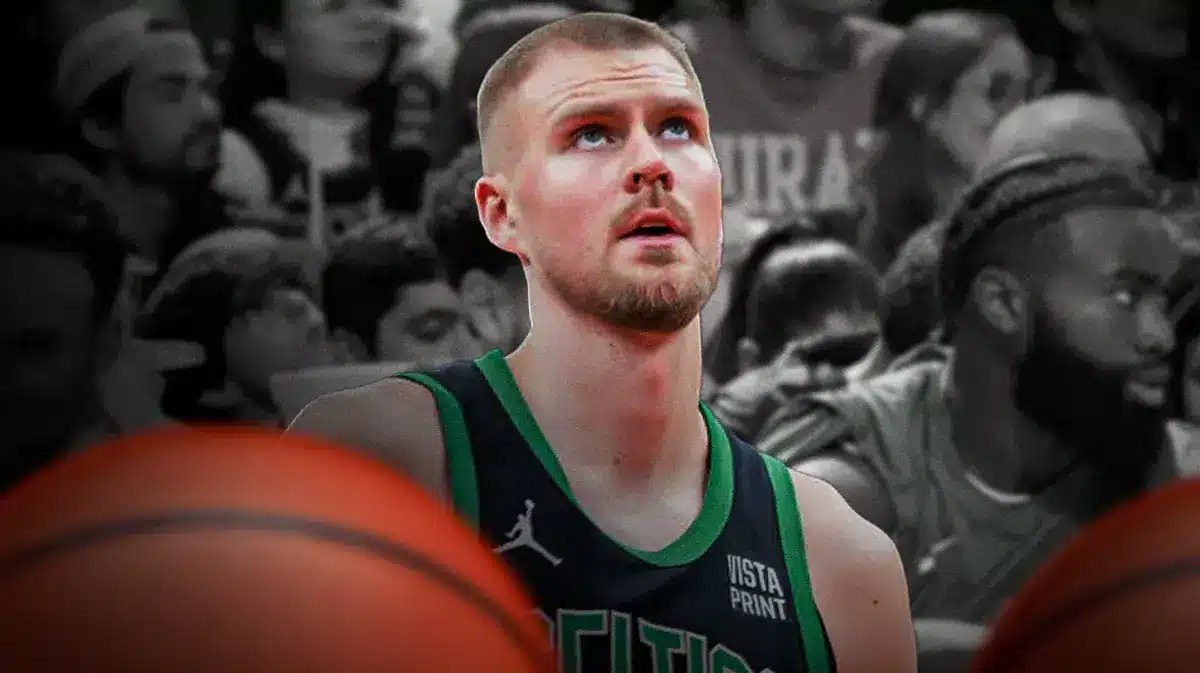 Celtics' Kristaps Porzingis looking serious sitting on an NBA sideline.