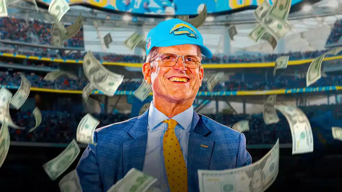 Jim Harbaugh surrounded by cash wearing a Chargers hat