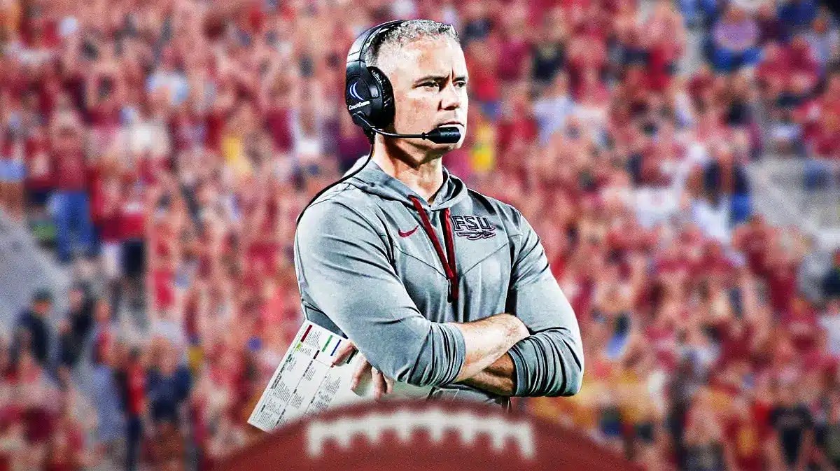 Florida State football coach Mike Norvell with fans cheering in the background.