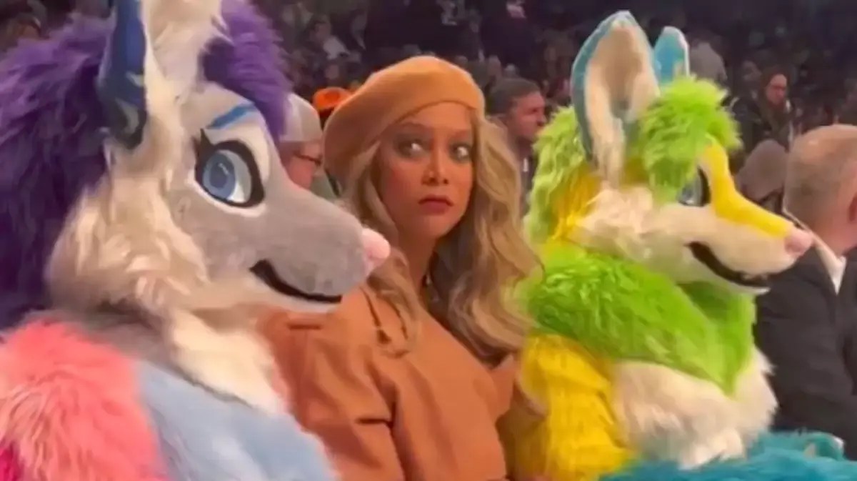 Tyra Banks hilariously staring down one of the furries she's sitting between at the Knicks-Nets game