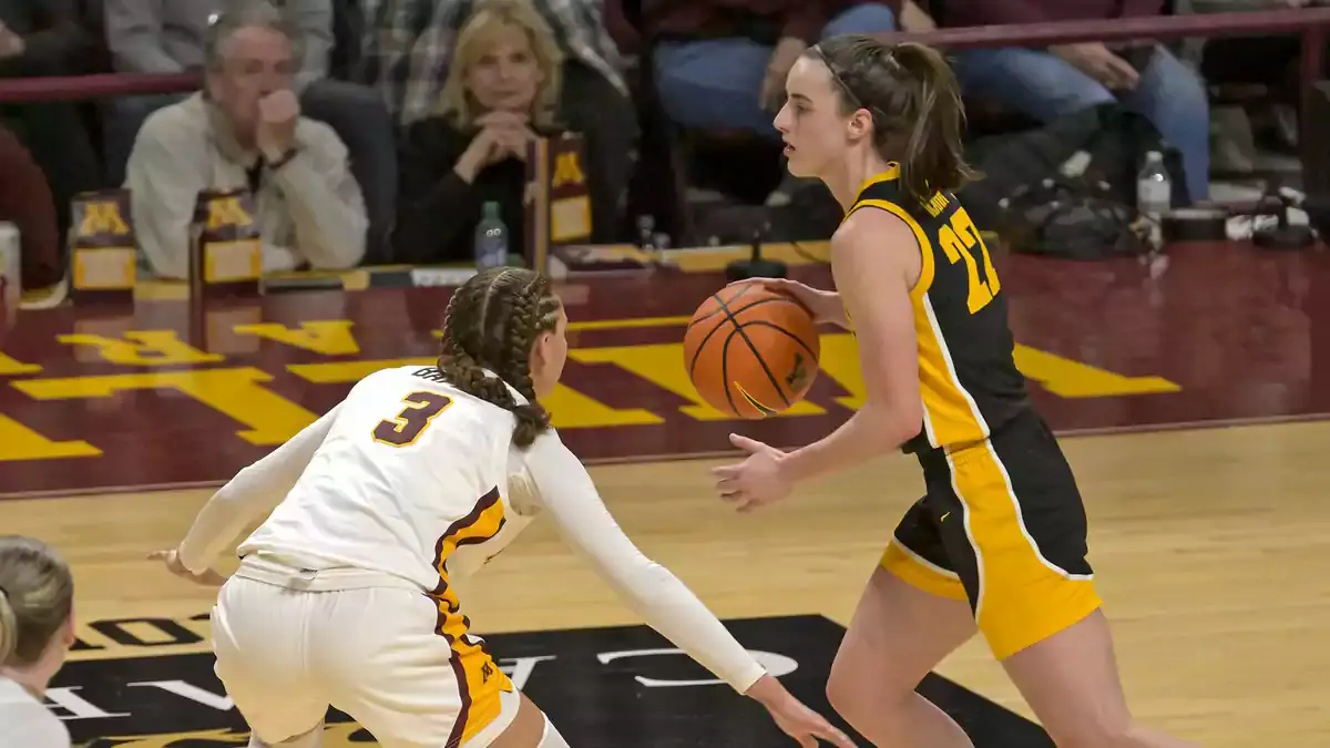 Iowa Hawkeyes guard Caitlin Clark (22) controls the ball as Minnesota Golden Gophers guard Amaya Battle (3) defends during the fourth quarter at Williams Arena. Mandatory Credit: Nick Wosika-USA TODAY Sports