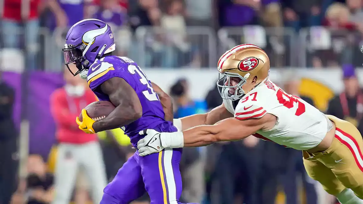 Minnesota Vikings running back Cam Akers (31) runs with the ball against the San Francisco 49ers defensive end Nick Bosa (97) in the second quarter at U.S. Bank Stadium