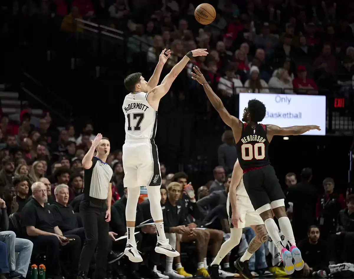 San Antonio Spurs forward Doug McDermott (17) scores a three point basket during the second half against Portland Trail Blazers guard Scoot Henderson (00) at Moda Center.
