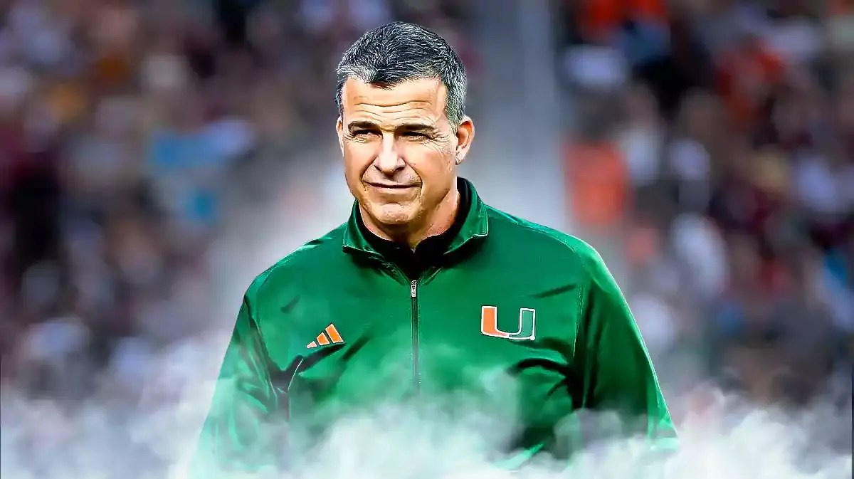 Miami football head coach Mario Cristobal coming out of the smoke