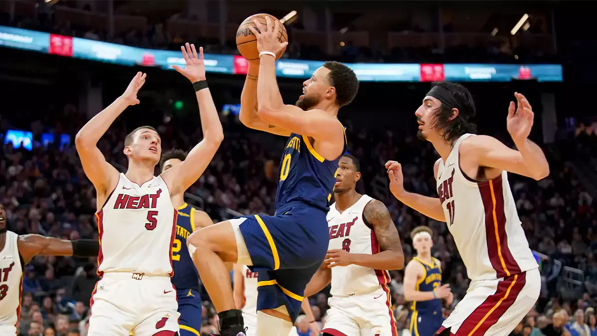Golden State Warriors guard Stephen Curry (30) drives to the hoop between Miami Heat forward Nikola Jovic (5) and forward Jaime Jaquez Jr. (11) in the fourth quarter at the Chase Center.