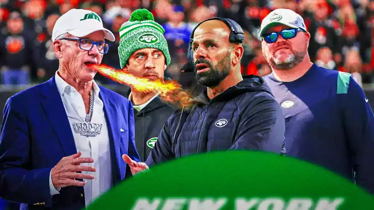 Jets owner Woody Johnson has smoke coming out of his ears or fire from his eyes or mouth. He’s standing over a nervous looking Robert Saleh and Joe Douglas. Aaron Rodgers is watching in background.