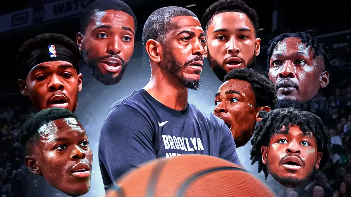 Nets coach Kevin Ollie in the middle from at least the waist up surrounded by the heads of Nets players Ben Simmons, Nic Claxton, Mikal Bridges, Cam Thomas, Dorian Finney-Smith, Day’Ron Sharpe, Dennis Schroder