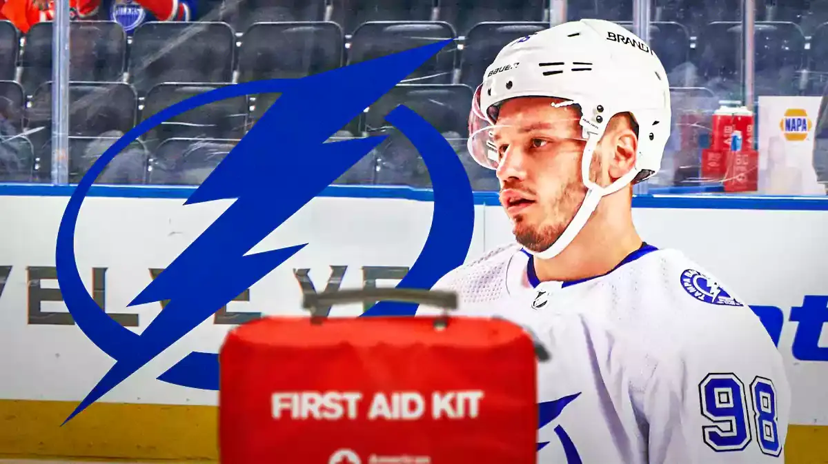 Mikhail Sergachev in middle of image looking stern, TB Lightning logo, first aid kit, hockey rink in background