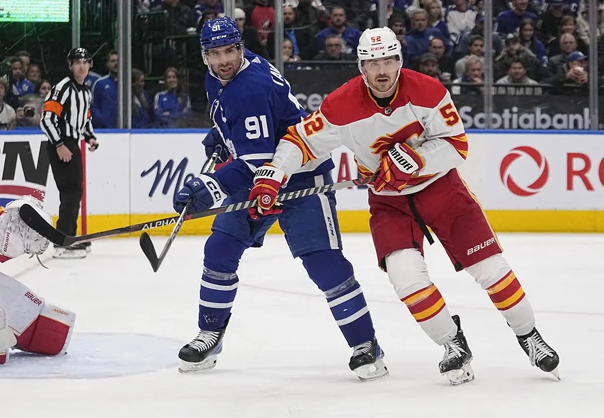 Calgary Flames defenseman Noah Hanifin (55) battles with Toronto Maple Leafs forward John Tavares (91) for position during the third period at Scotiabank Arena.