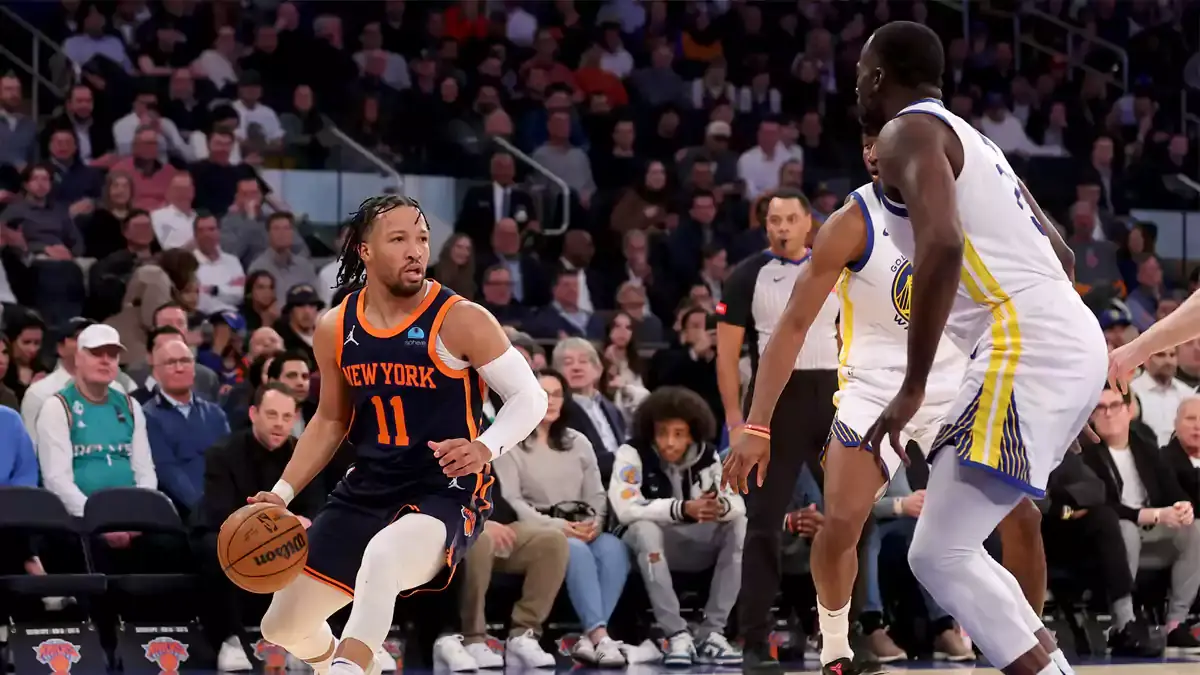 New York Knicks guard Jalen Brunson (11) controls the ball against Golden State Warriors forward Jonathan Kuminga (00) and forward Draymond Green (23) during the first quarter at Madison Square Garden.
