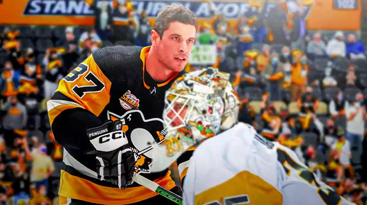 Penguins players Sidney Crosby on left, Tristan Jarry on the right. Fans in background.