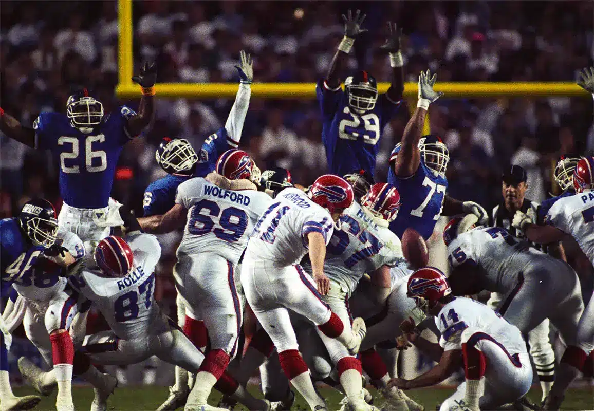 Buffalo Bills kicker Scott Norwood (11) attempts a field goal under the hold of quarterback Frank Reich (14) during Super Bowl XXV against the New York Giants at Tampa Stadium. The Giants defeated the Bills 19-20