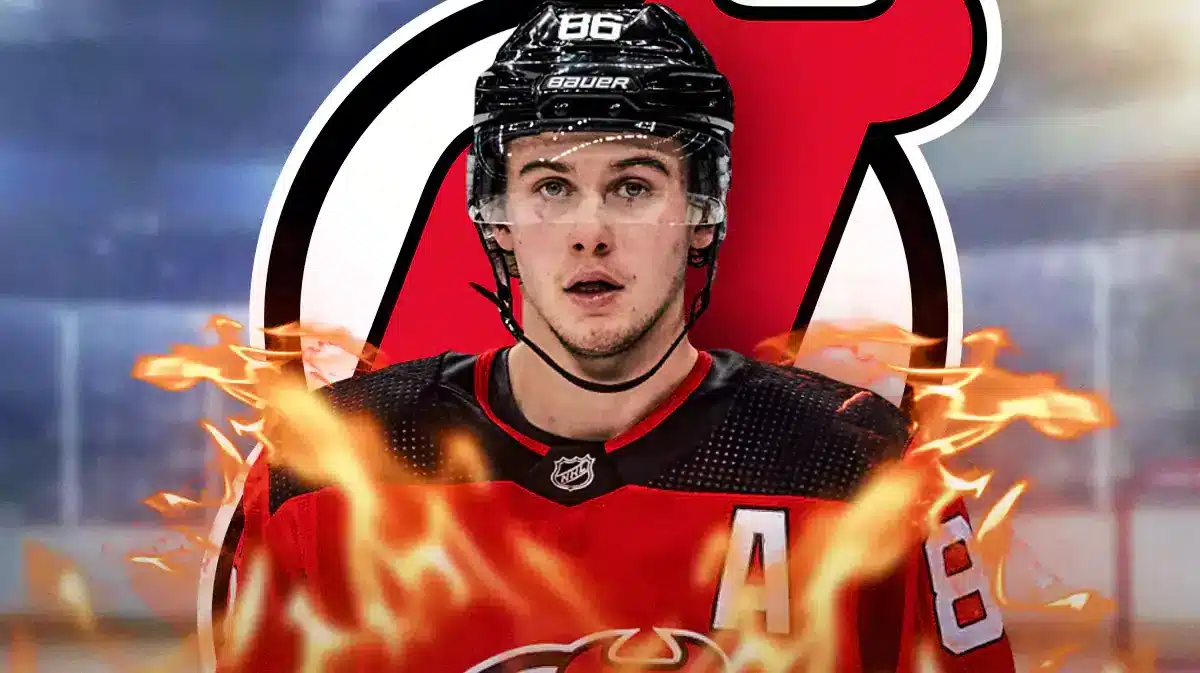 Jack Hughes in middle of image looking happy with fire around him , NJ Devils logo, hockey rink in background