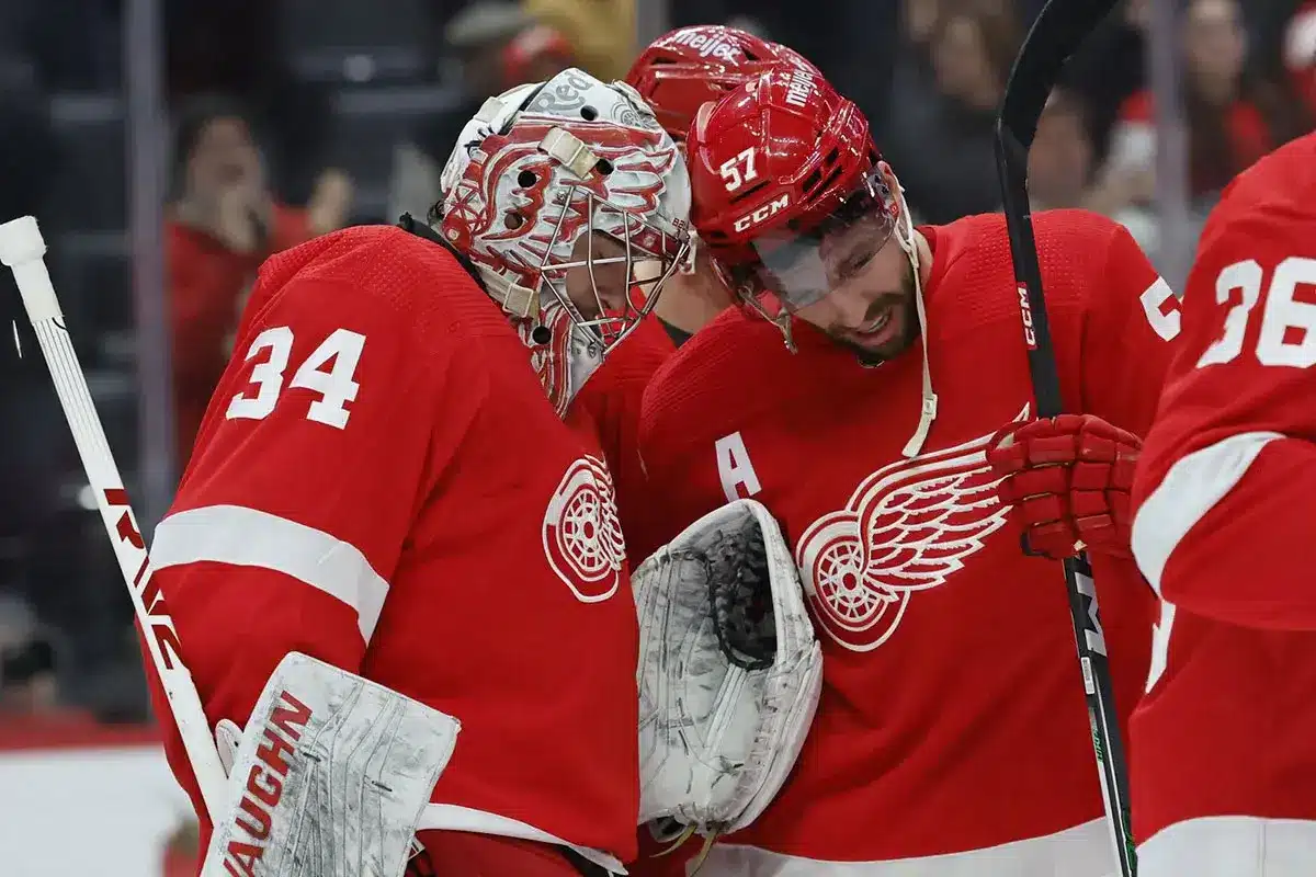 Detroit Red Wings goaltender Alex Lyon (34) receives congratulations from left wing David Perron (57) after the game against the Philadelphia Flyers at Little Caesars Arena.