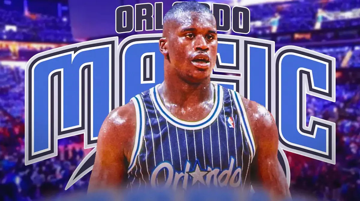 Shaquille O' Neal stands in front of Magic logo, Shaq jersey retirement press conference room sits in the background