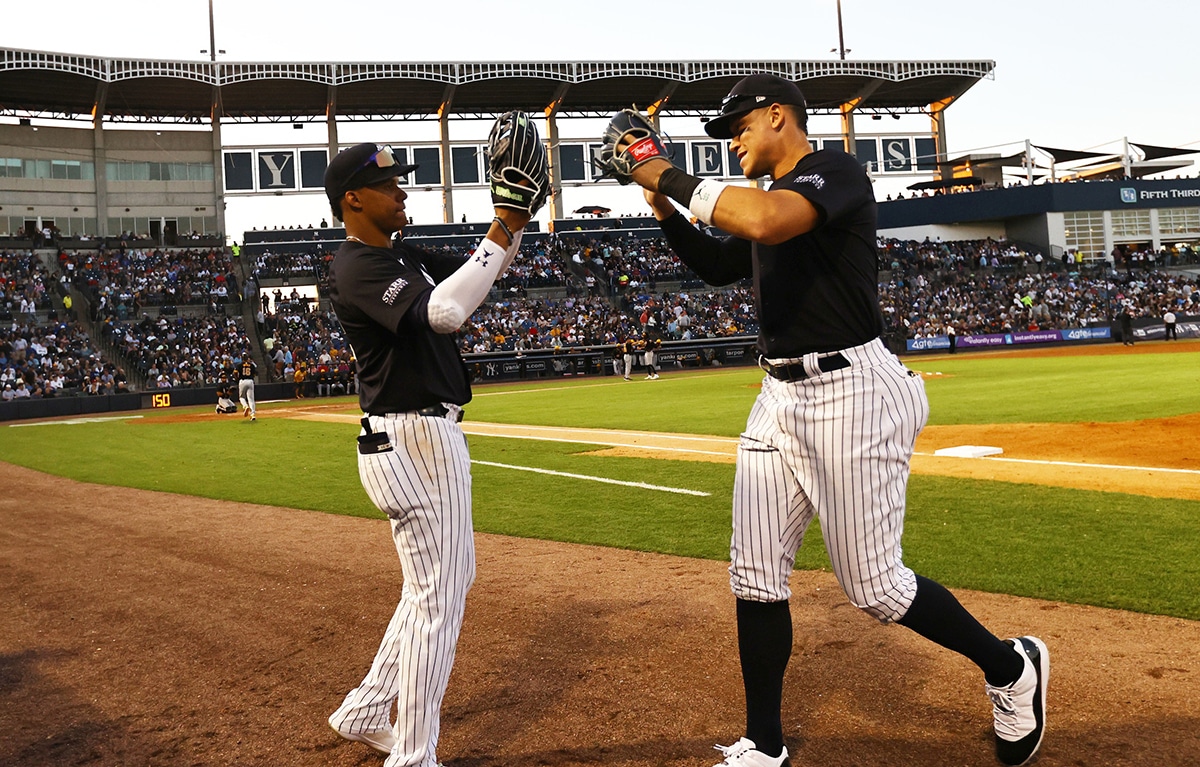 New York Yankees left fielder Juan Soto (22) and right fielder Aaron Judge (99) high five against the Pittsburgh Pirates at George M. Steinbrenner Field.
