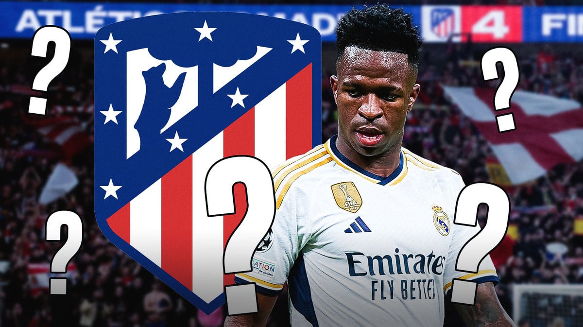Vinicius Jr in front of the Atletico Madrid logo, questionmarks and fans in the back