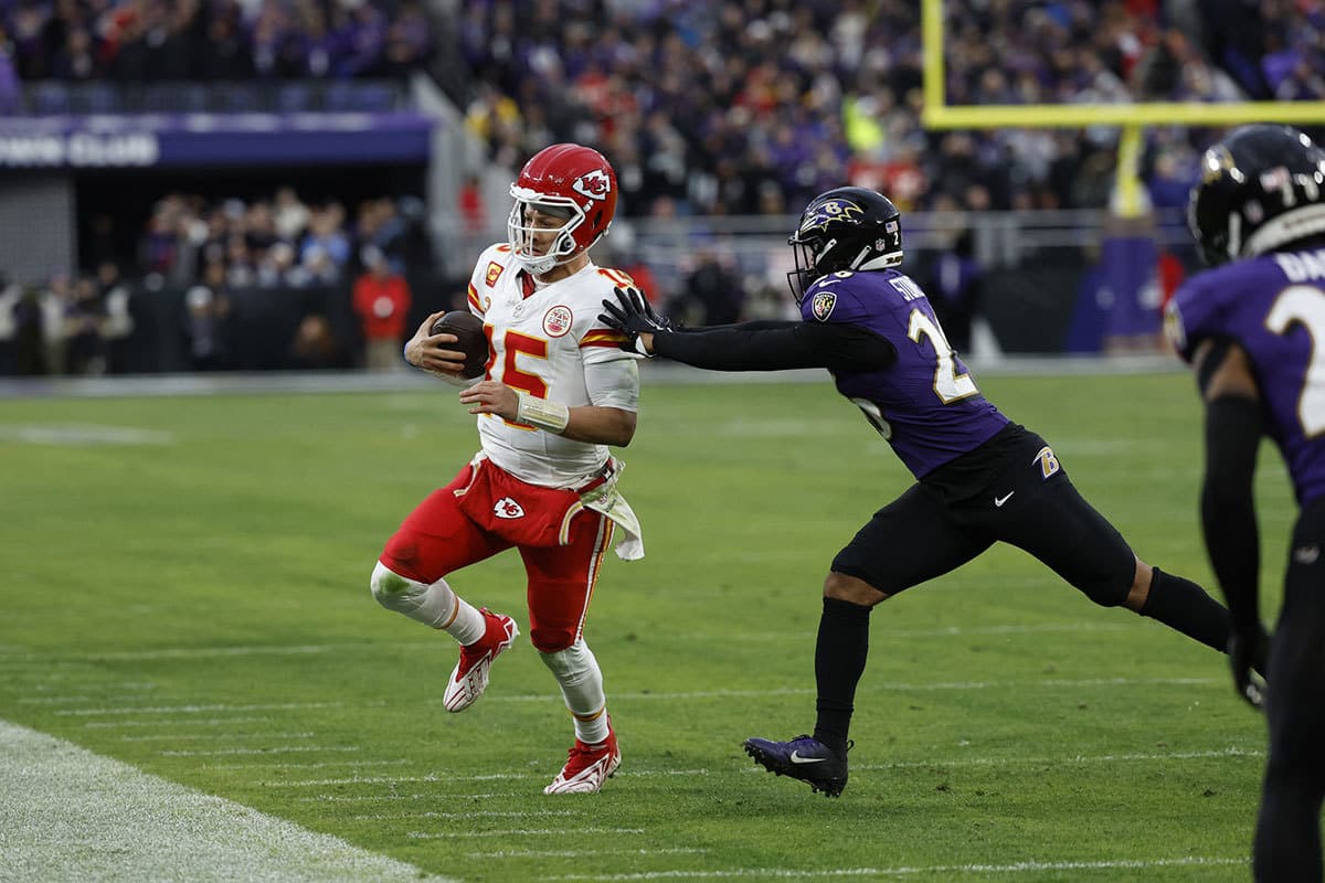  Baltimore Ravens safety Geno Stone (26) pushes Kansas City Chiefs quarterback Patrick Mahomes (15) out of bounds during the second half in the AFC Championship football game at M&T Bank Stadium