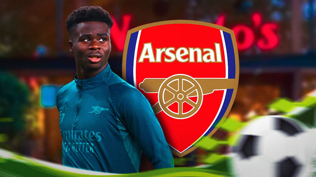Bukayo Saka in a Nando’s restaurant, the Arsenal logo on the wall