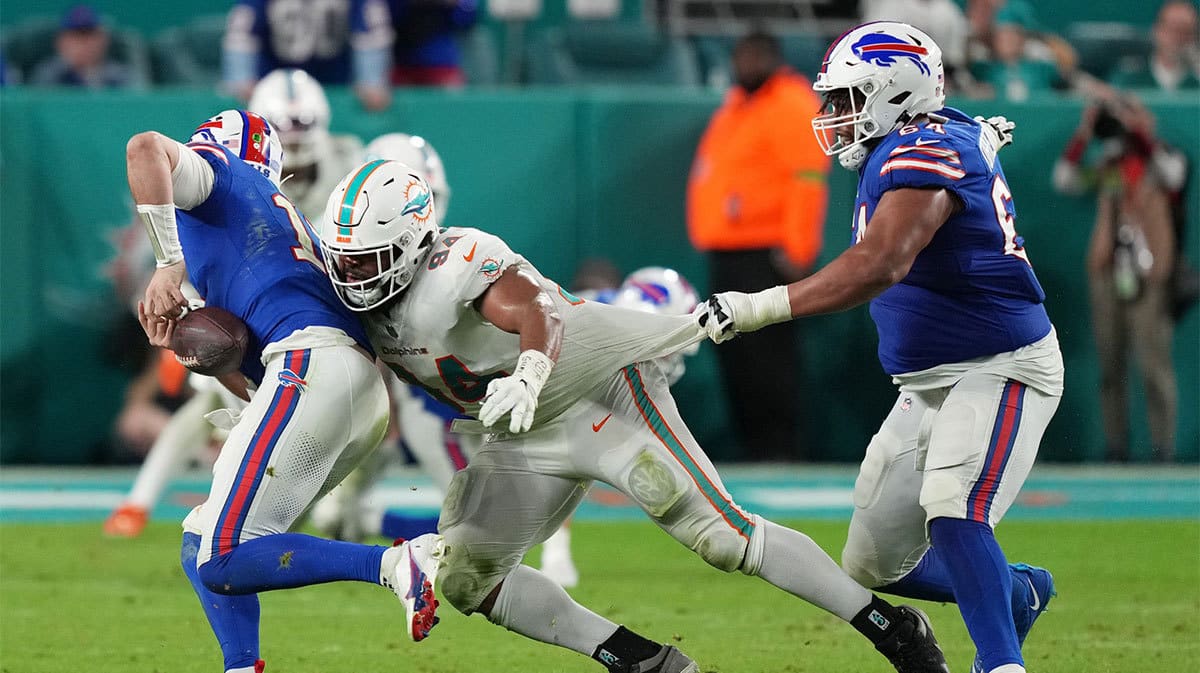 Miami Dolphins defensive tackle Christian Wilkins (94) strips the ball from Buffalo Bills quarterback Josh Allen (17) as guard O'Cyrus Torrence (64) defends on the play during the second half at Hard Rock Stadium.