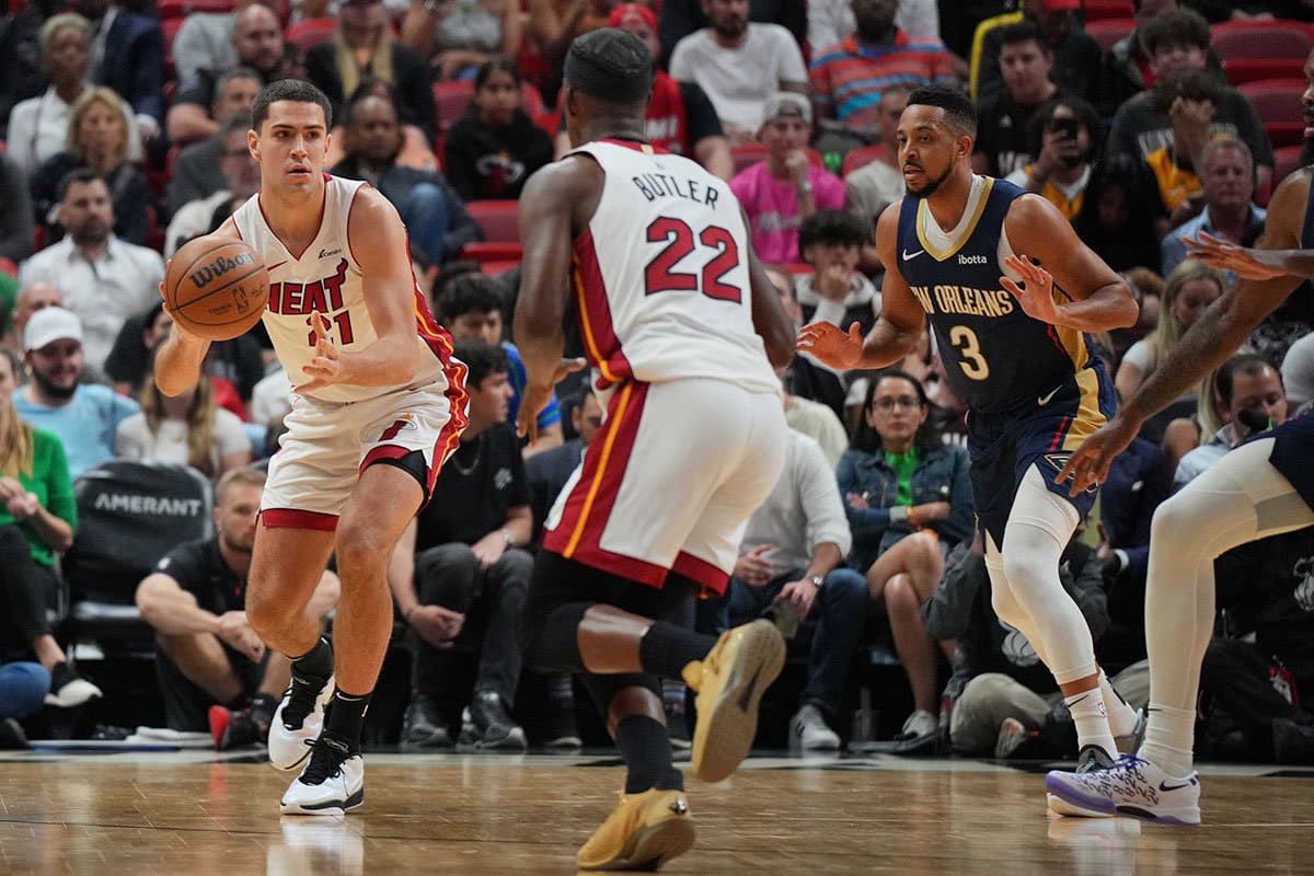 Miami Heat forward Cole Swider (21) passes the ball to forward Jimmy Butler (22) during the first half against the New Orleans Pelicans at Kaseya Center.