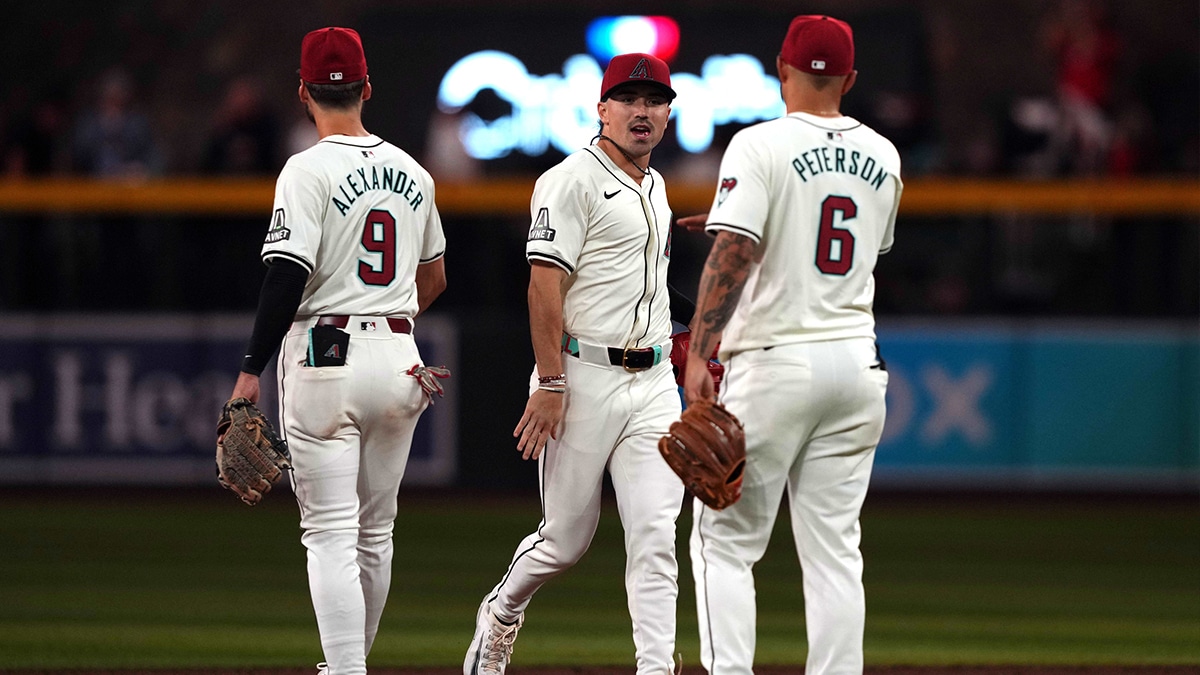 Arizona Diamondbacks right fielder Corbin Carroll (center) celebrates with designated hitter Blaze Alexander (9) and third baseman Jace Peterson (6) after the ninth inning against the Colorado Rockies at Chase Field.