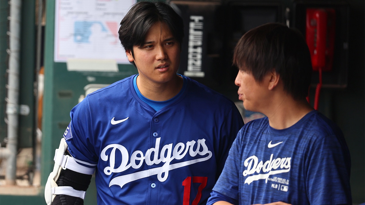 os Angeles Dodgers designated hitter Shohei Ohtani talks with translator Ippei Mizuhara in the dugout against the San Francisco Giants during a spring training baseball game at Camelback Ranch-Glendale. 