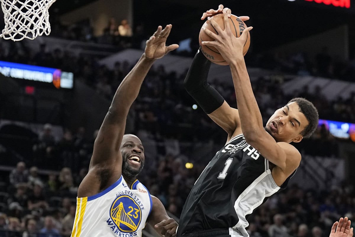 San Antonio Spurs forward Victor Wembanyama (1) grabs a rebound away from Golden State Warriors forward Draymond Green (23) during the first half at Frost Bank Center. 
