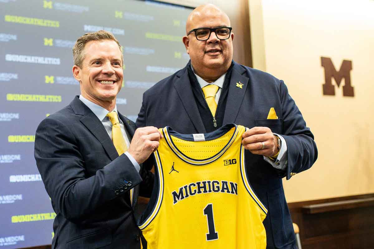U-M athletic director Warde Manuel presents a jersey to new men's basketball head coach Dusty May during an introductory press conference for Dusty May at Junge Family Champions Center