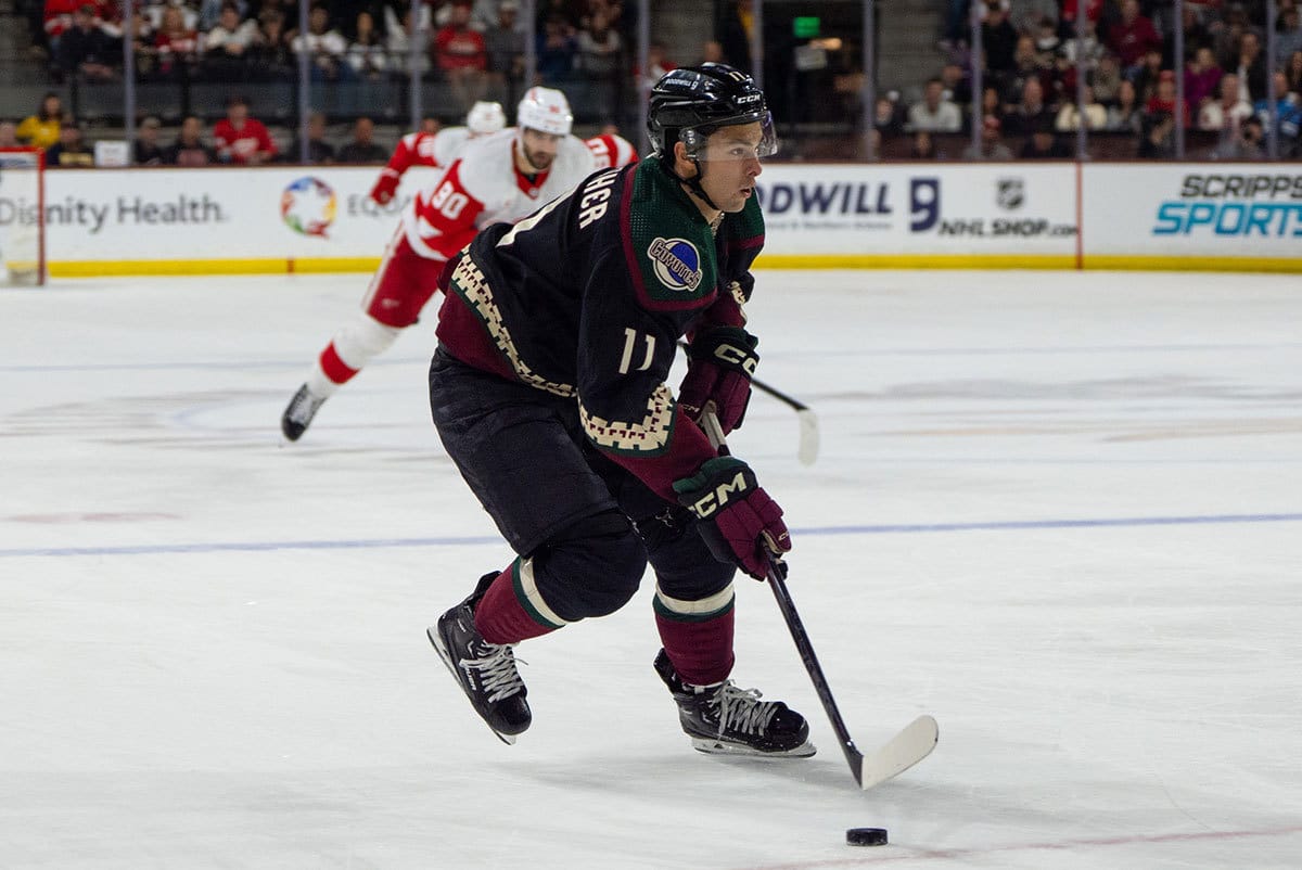 Arizona Coyotes forward Dylan Guenther (11) brings the puck down the ice in the second period during a game against the Detroit Red Wings at Mullett Arena.