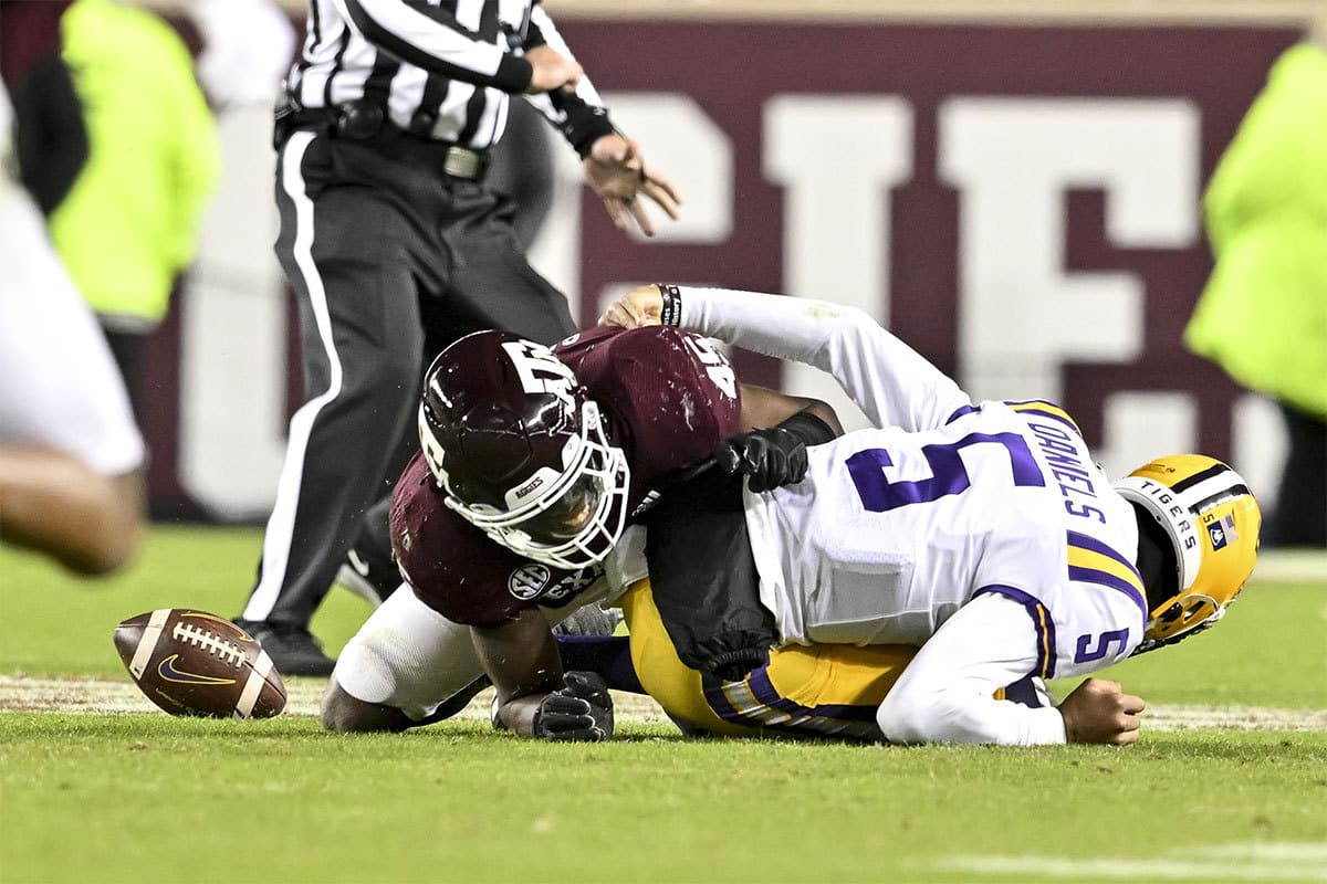 Texas A&M Aggies linebacker Edgerrin Cooper (45) tackles LSU Tigers quarterback Jayden Daniels (5) to cause a fumble during the third quarter at Kyle Field