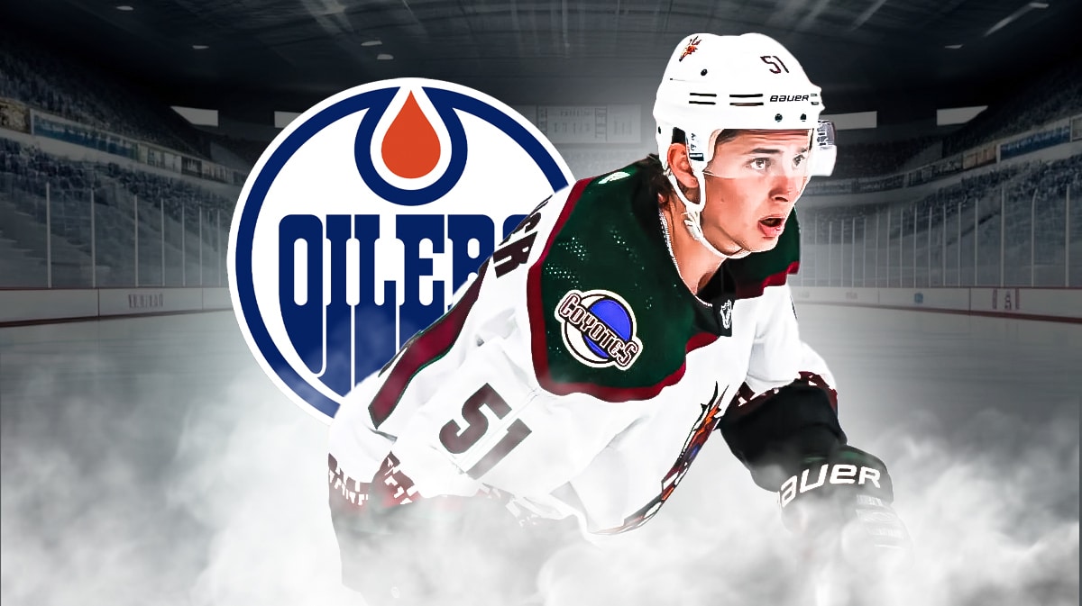 Troy Stecher looking thoughtful, Edmonton Oilers logo, hockey rink in background