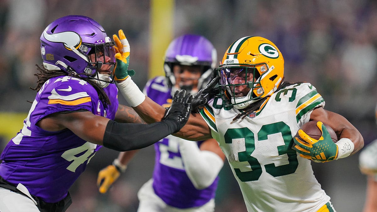 Green Bay Packers running back Aaron Jones (33) runs with the ball against the Minnesota Vikings safety Josh Metellus (44) in the first quarter at U.S. Bank Stadium