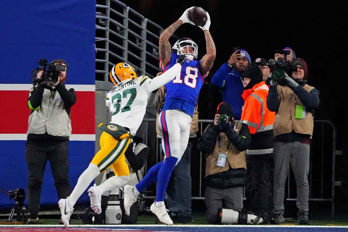 New York Giants wide receiver Isaiah Hodgins (18) catches a touchdown against Green Bay Packers cornerback Carrington Valentine (37) during the third quarter at MetLife Stadium.