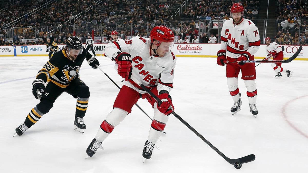 Carolina Hurricanes left wing Jake Guentzel (59) skates with the puck as Pittsburgh Penguins defenseman Erik Karlsson (65) chases during the first period at PPG Paints Arena
