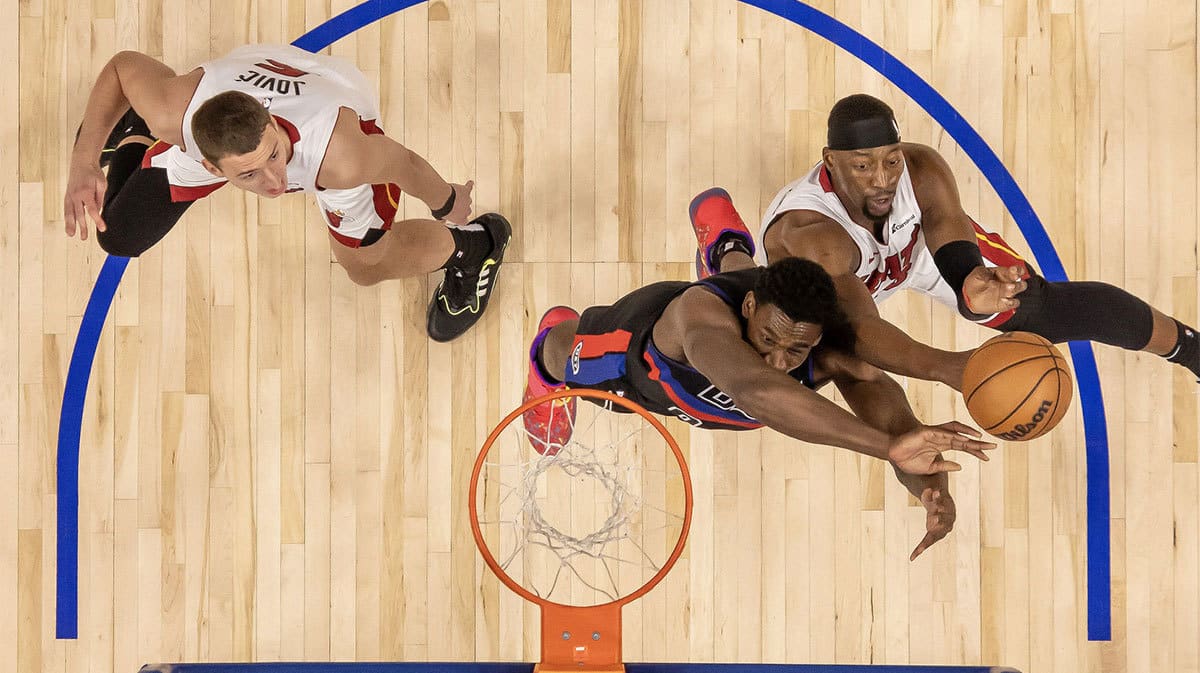 Detroit Pistons center Jalen Duren (0) battles for the rebound with Miami Heat center Bam Adebayo (13) and forward Nikola Jovic (5) during the in the first half at Little Caesars Arena.