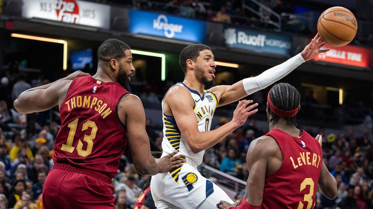 Indiana Pacers guard Tyrese Haliburton (0) passes the ball while Cleveland Cavaliers center Tristan Thompson (13) and guard Caris LeVert (3) defend in the first half at Gainbridge Fieldhouse