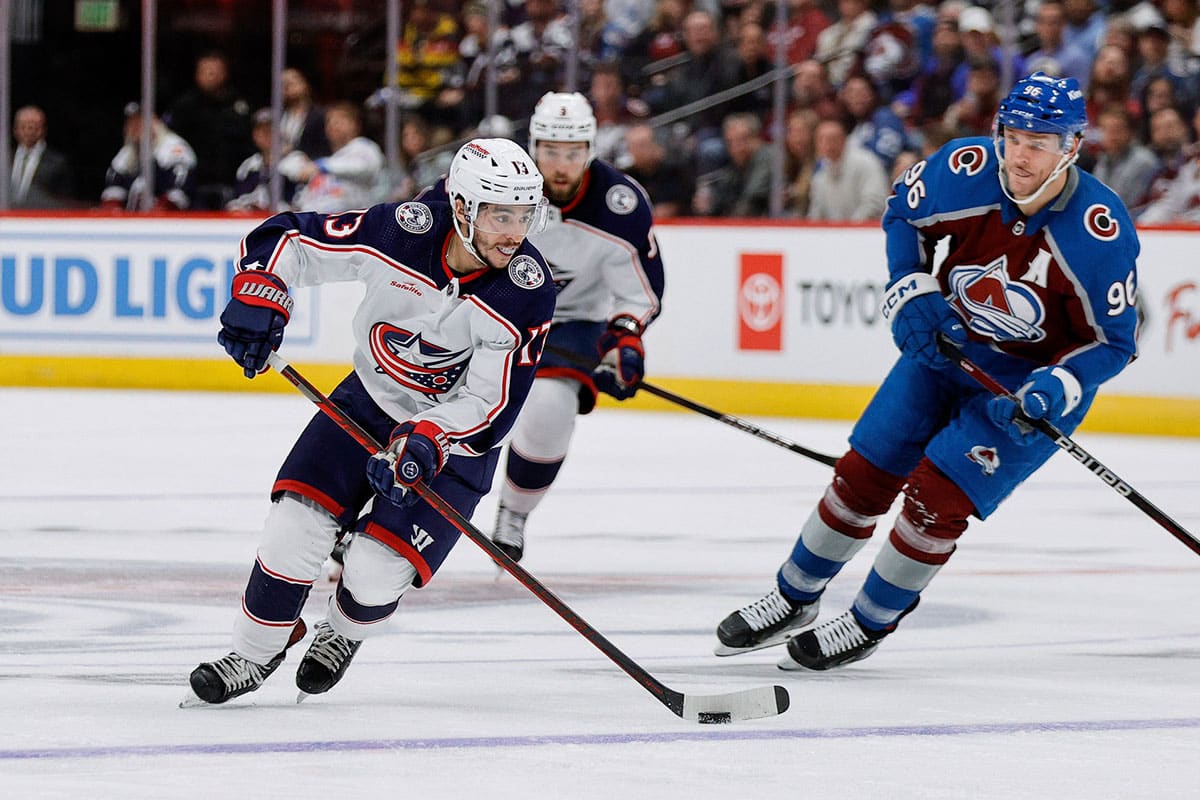 Columbus Blue Jackets left wing Johnny Gaudreau (13) controls the puck ahead of Colorado Avalanche right wing Mikko Rantanen (96) in the third period at Ball Arena.
