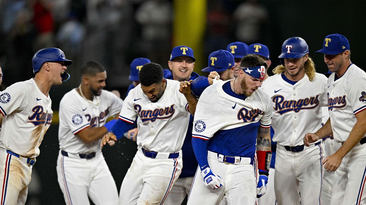Texas Rangers catcher Jonah Heim (28) and third baseman Josh Jung (6) and second baseman Marcus Semien (2) and left fielder Travis Jankowski (16) celebrate after Heim hits a walk off single against the Chicago Cubs during the tenth inning at Globe Life Field. 