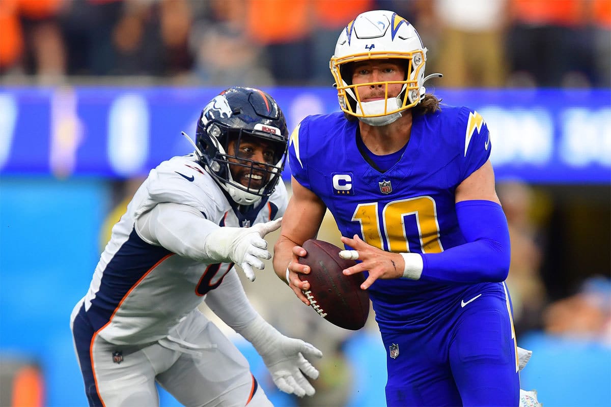 Los Angeles Chargers quarterback Justin Herbert (10) moves out to pass against the defense of Denver Broncos linebacker Jonathon Cooper (0) during the first half at SoFi Stadium.