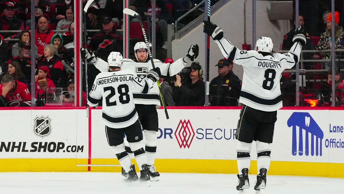 Los Angeles Kings center Pierre-Luc Dubois (80) is congratulated by center Jaret Anderson-Dolan (28) and defenseman Drew Doughty (8) after his goal against the Carolina Hurricanes during the third period at PNC Arena.