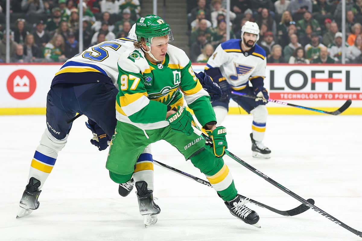 Minnesota Wild left wing Kirill Kaprizov (97) and St. Louis Blues defenseman Colton Parayko (55) compete for the puck during the first period at Xcel Energy Center.