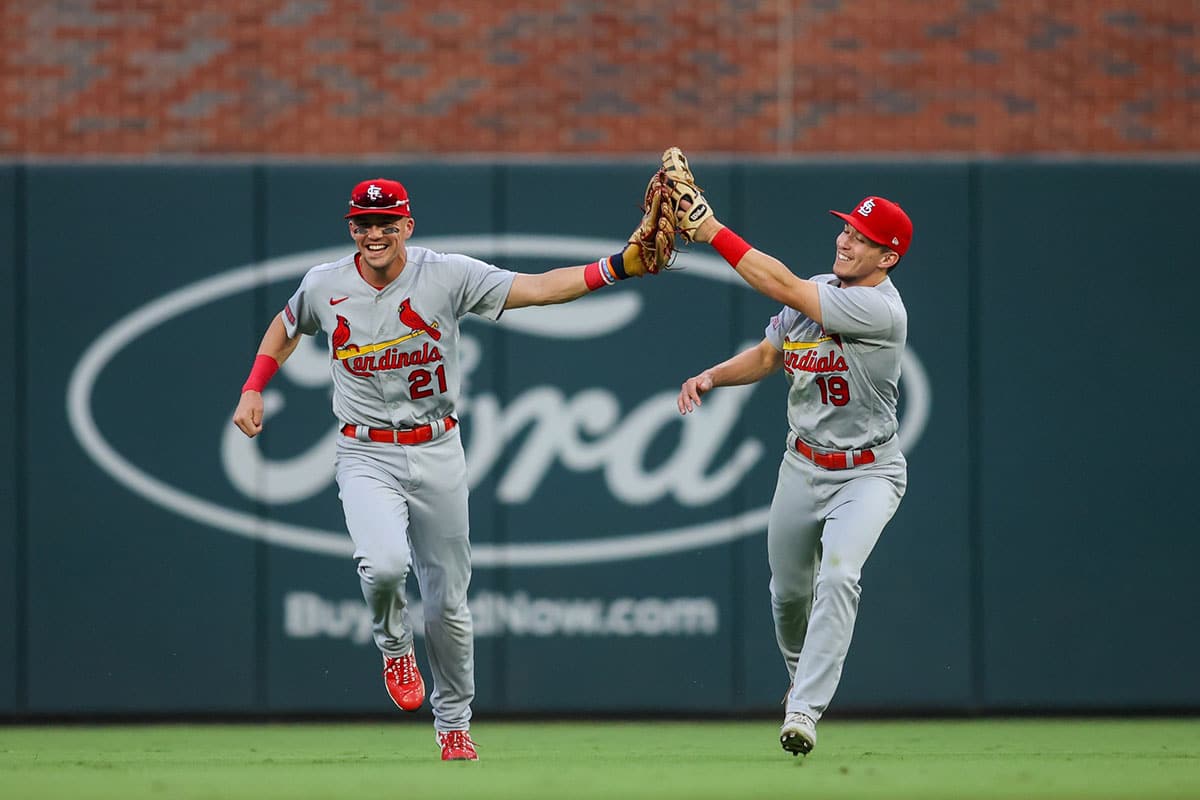 St. Louis Cardinals center fielder Tommy Edman (19) celebrates after a diving catch with right fielder Lars Nootbaar (21) against the Atlanta Braves in the second inning at Truist Park