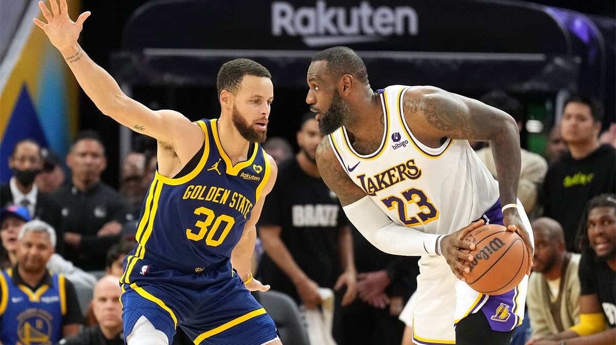 Los Angeles Lakers forward LeBron James (23) handles the ball against Golden State Warriors guard Stephen Curry (30) during overtime at Chase Center. 